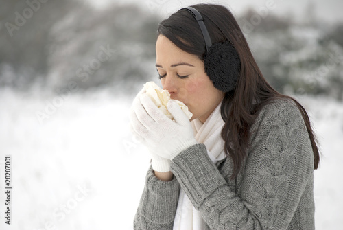 Tableau sur toile Woman sneezing in the snow
