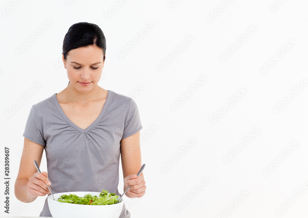 Pretty woman preparing a salad with tomatoes in the kitchen Pretty woman preparing a salad with tomatoes in the kitchen