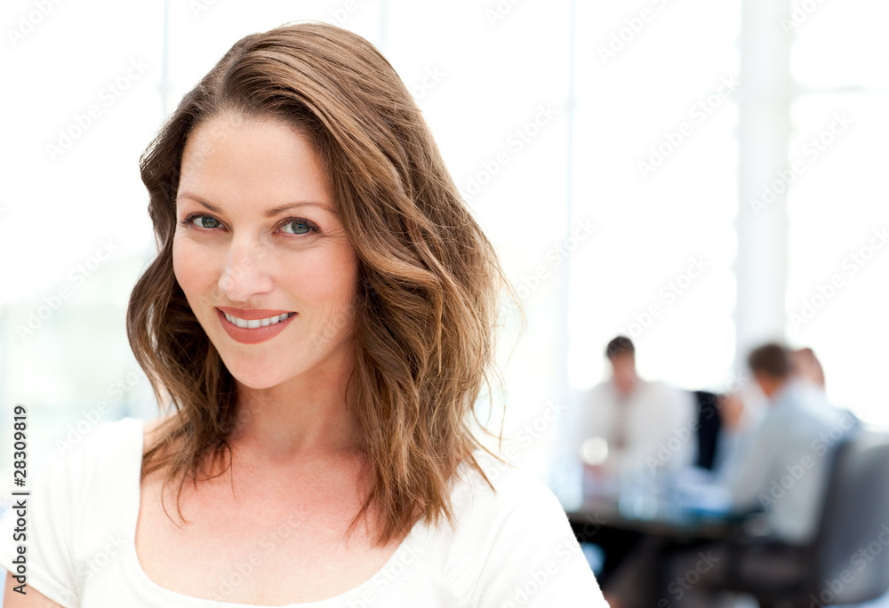 Obraz premium Relaxed businesswoman standing in front of her team while workin