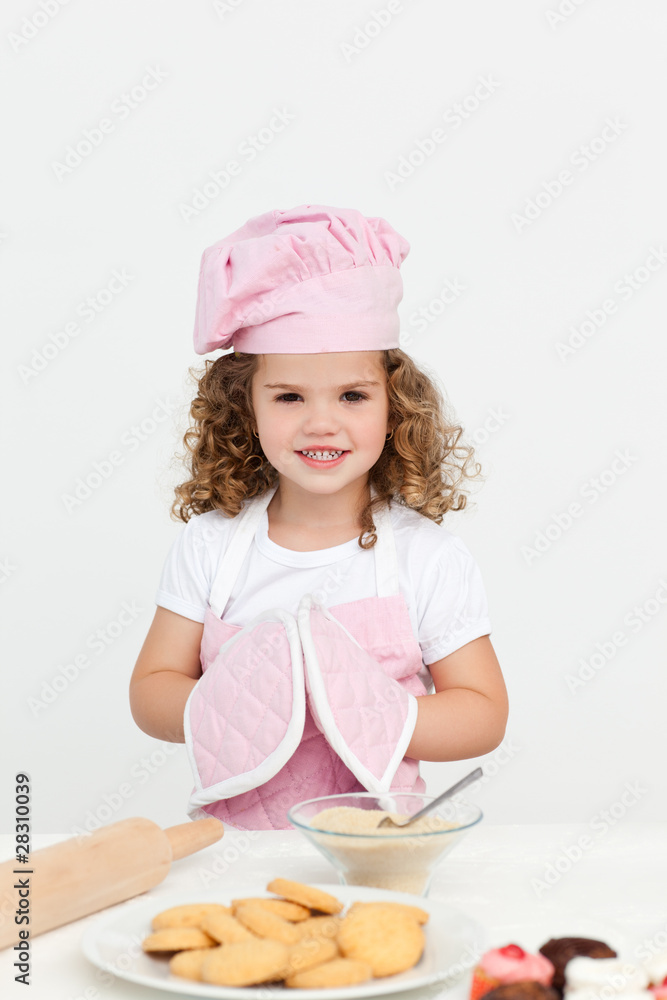 Cute girl with kitchen gloves presenting her biscuits Cute girl with kitchen gloves presenting her biscuits