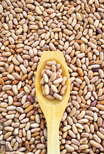 Fotografie Wooden spoon and dried pinto beans.