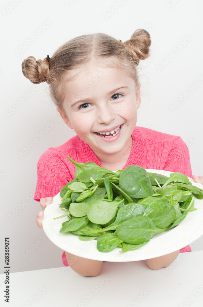 Little girl with plate of spinach - healthy food Little girl with plate of spinach - healthy food