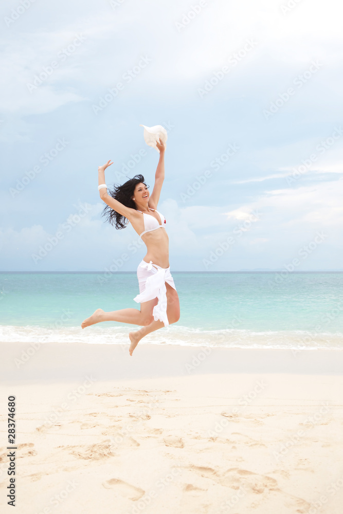 happy young woman jumping in the beach happy young woman jumping in the beach