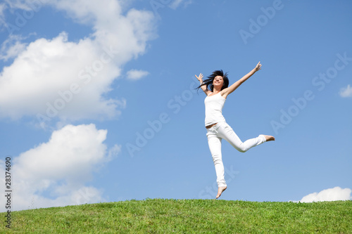 pretty young woman jumping on green grass © Dmytro Sunagatov