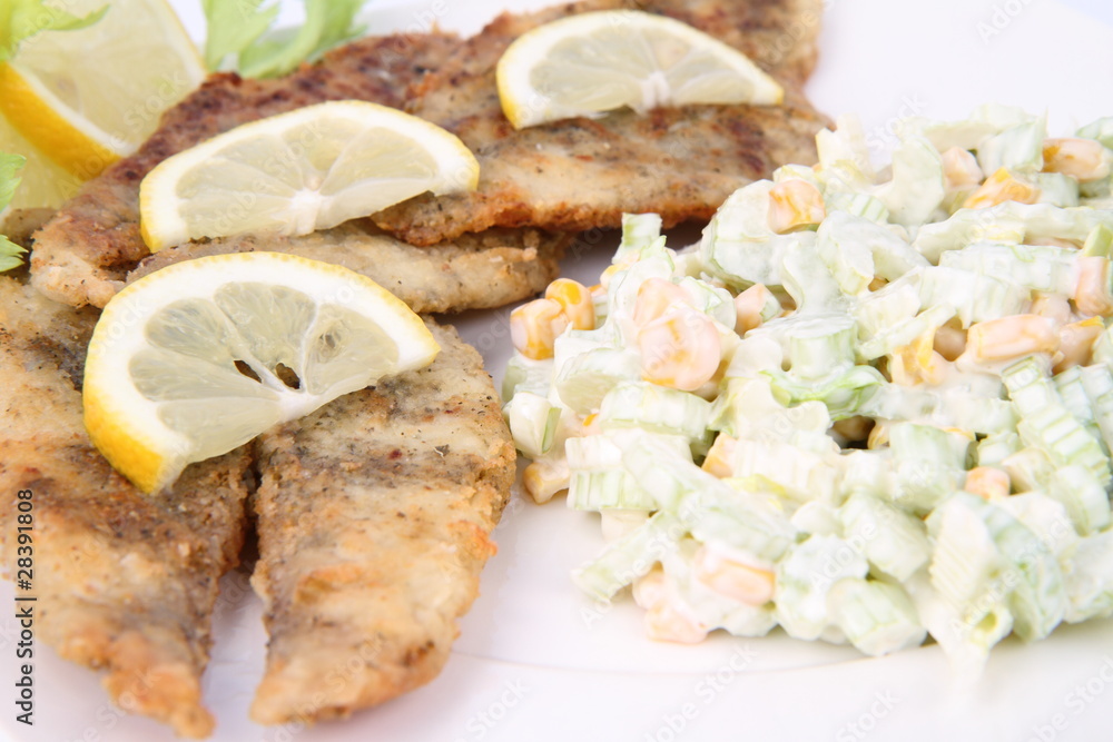 Fried fish with side salad decorated with lemon Fried fish with side salad decorated with lemon