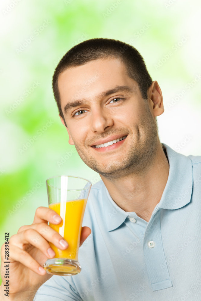 Portrait of smiling man drinking orange juice, outdoor Portrait of smiling man drinking orange juice, outdoor