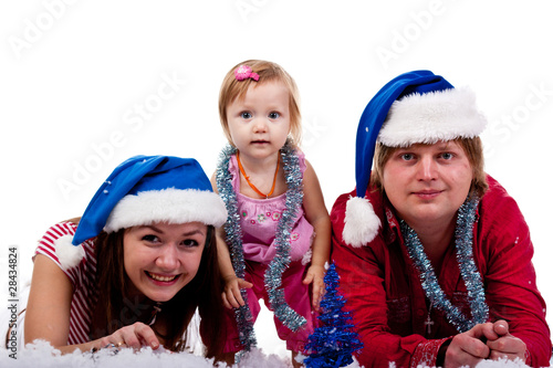 Family in Santa's hat lying in artificial snow