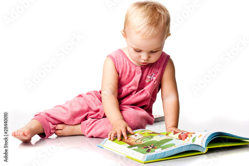 Beautiful baby girl reading a book