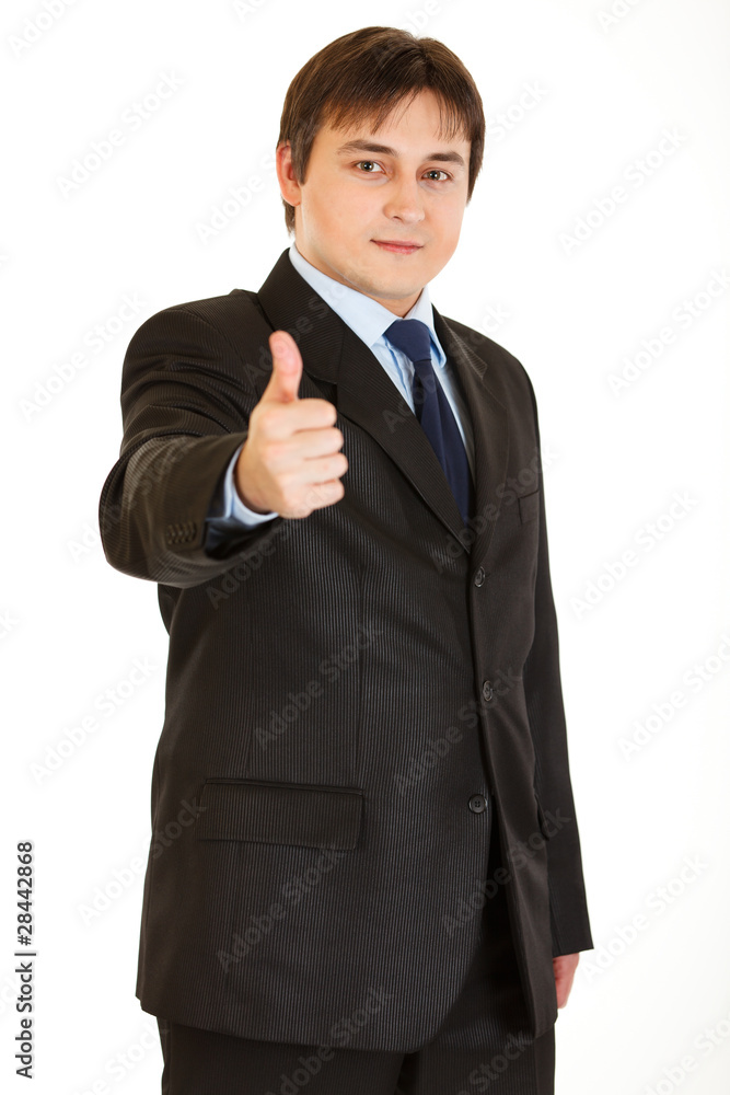 Smiling young businessman showing thumbs up gesture Smiling young businessman showing thumbs up gesture