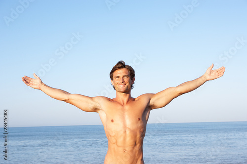 Young man stretching on beach