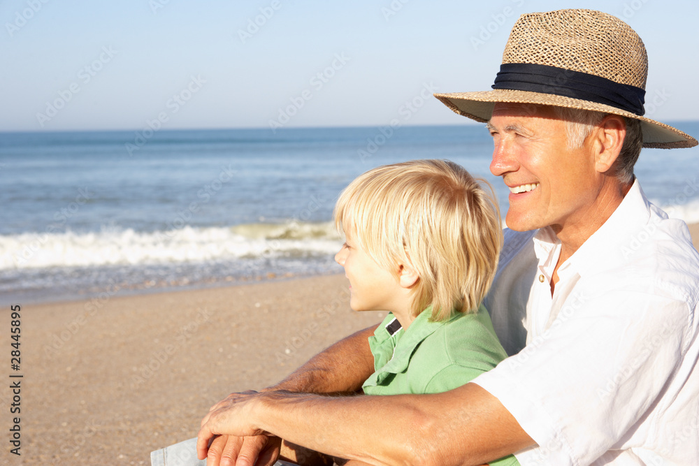 Grandfather with child on beach relaxing