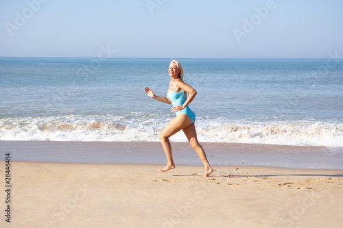 Senior woman running on beach