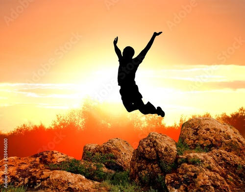 man silhouette jumping on a sunset background