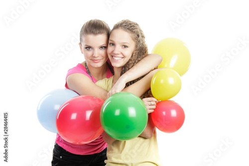 two smiling girls with balloons over white