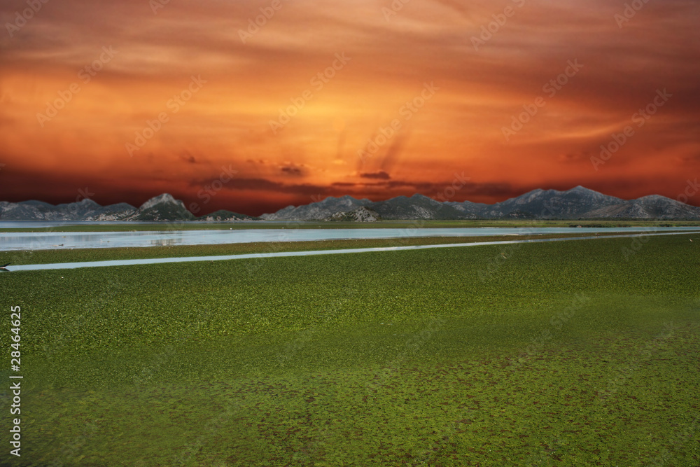 Beautiful sunset-grass and lake with mountain in backround Beautiful sunset-grass and lake with mountain in backround