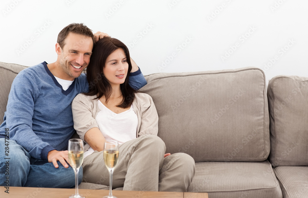 Relaxed couple watching television while drinking champagne Relaxed couple watching television while drinking champagne