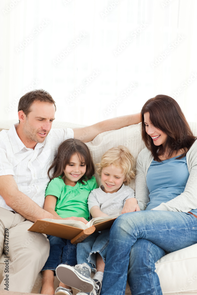 Cheerful family looking at a photo album together Cheerful family looking at a photo album together