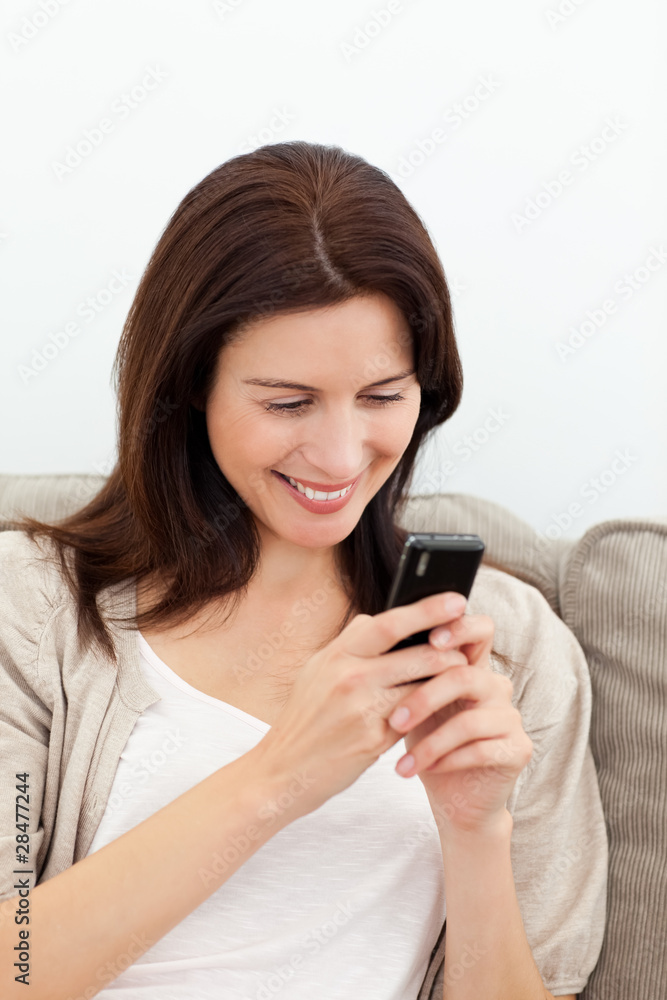Happy woman sending a message with her cellphone Happy woman sending a message with her cellphone