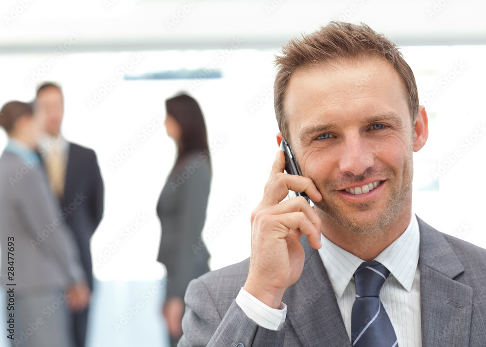 Happy businessman on the phone while his team working Happy businessman on the phone while his team working