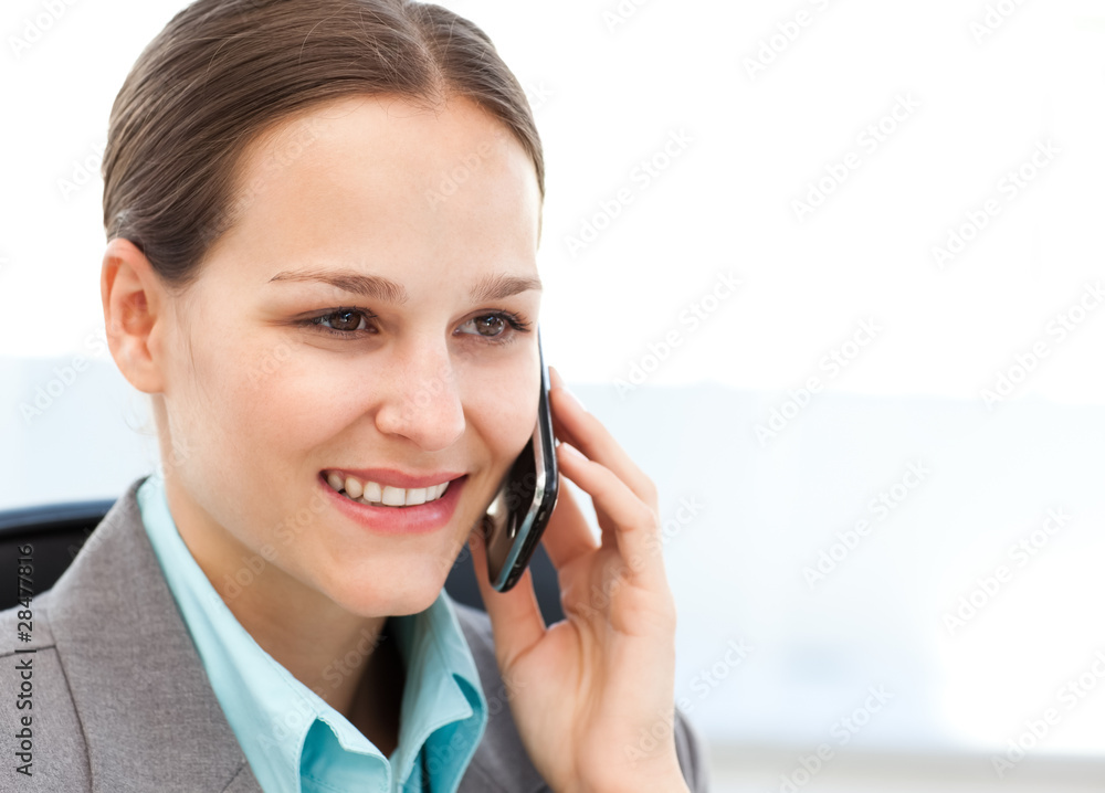 Female executive using her cellphone at her desk Female executive using her cellphone at her desk