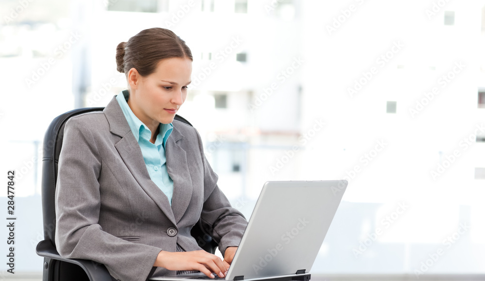 Cute businesswoman working on the laptop sitting at her desk Cute businesswoman working on the laptop sitting at her desk