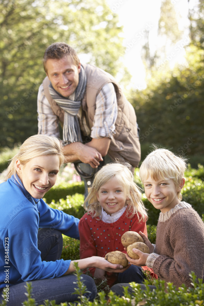 Young family sit together in garden