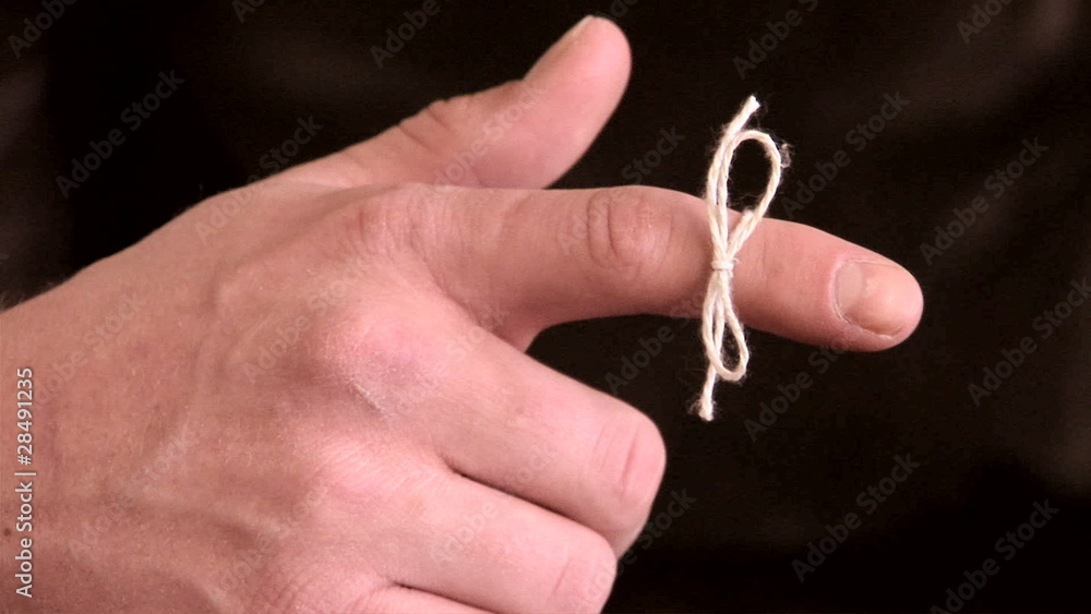 Close up of male hand with string tied on finger