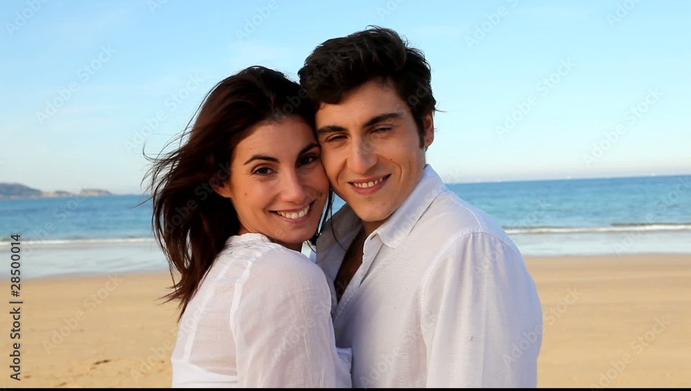 Happy young couple standing at the beach Happy young couple standing at the beach