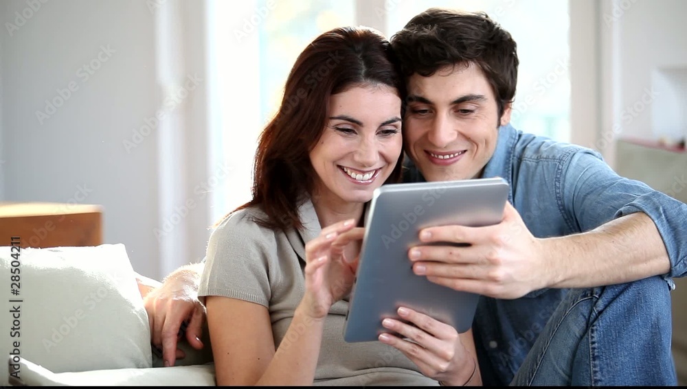 Couple surfing on internet with electronic tab Couple surfing on internet with electronic tab