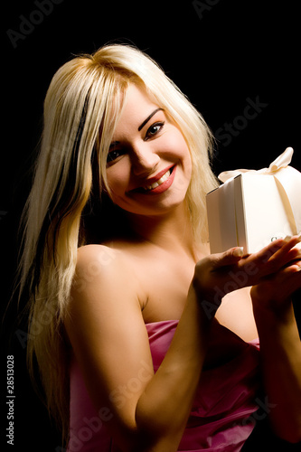 Ragazza bionda con regalo in mano su sfondo nero