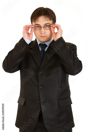 Modern businessman straightening eyeglasses isolated on white.