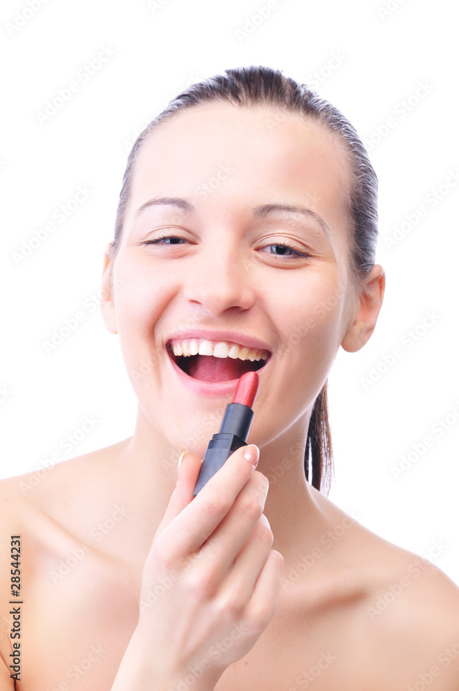young laughing woman is applying cosmetics on her face and looki young laughing woman is applying cosmetics on her face and looki