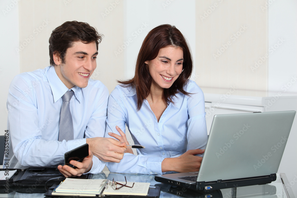 Office workers working on laptop computer Office workers working on laptop computer