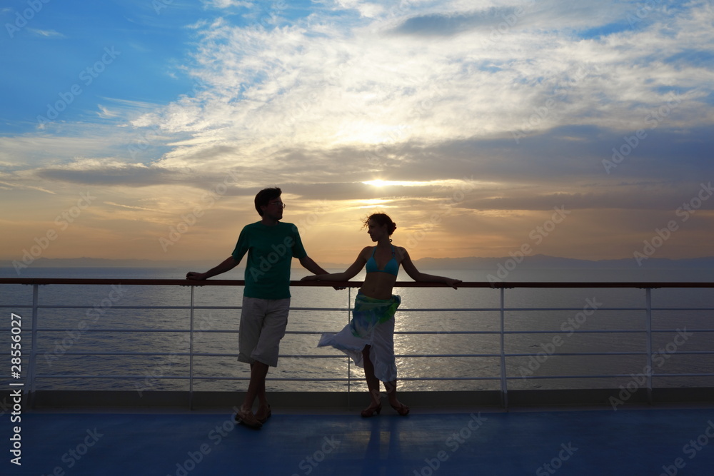 man and woman standing on deck of cruise ship.