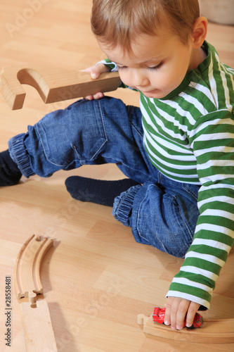 Kleinkind spielt mit Holzeisenbahn