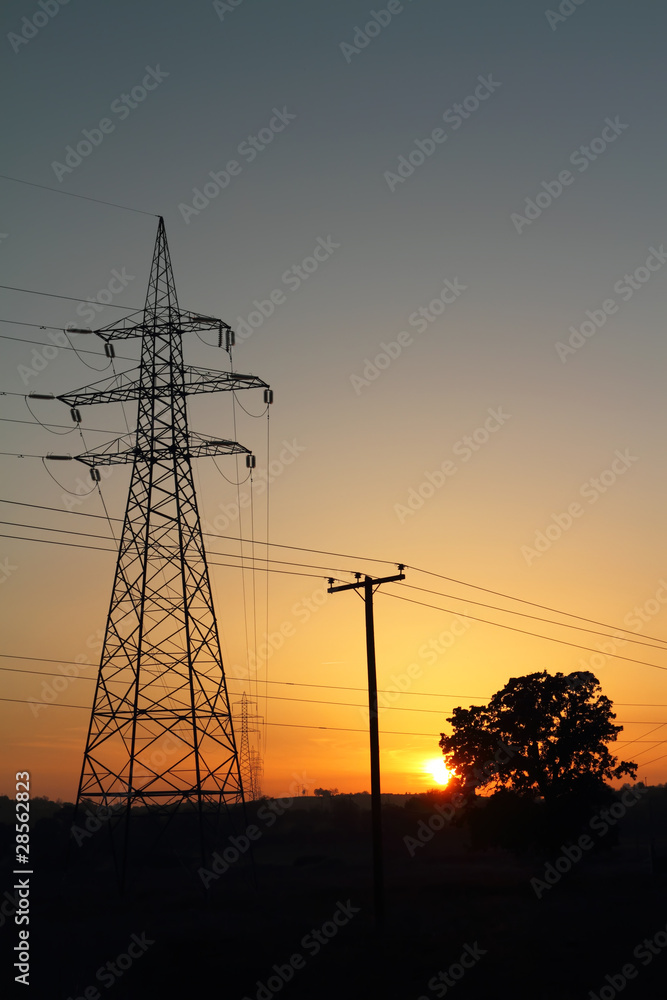 High voltage electricity pylon against sunset