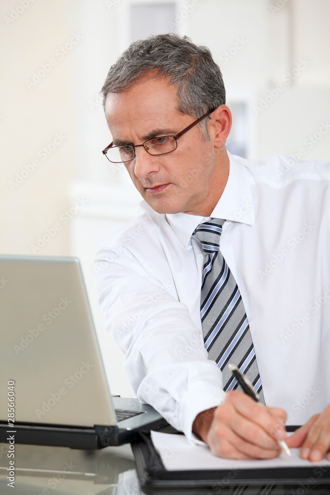 Portrait of businessman working on laptop computer Portrait of businessman working on laptop computer