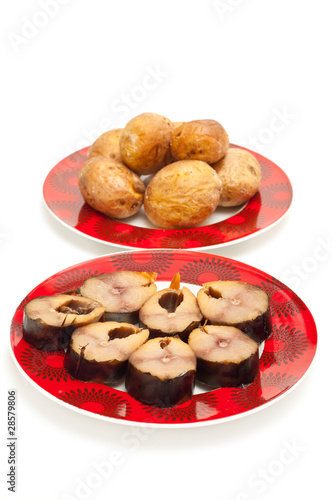 baked potatoes and fish on a plate isolated on white