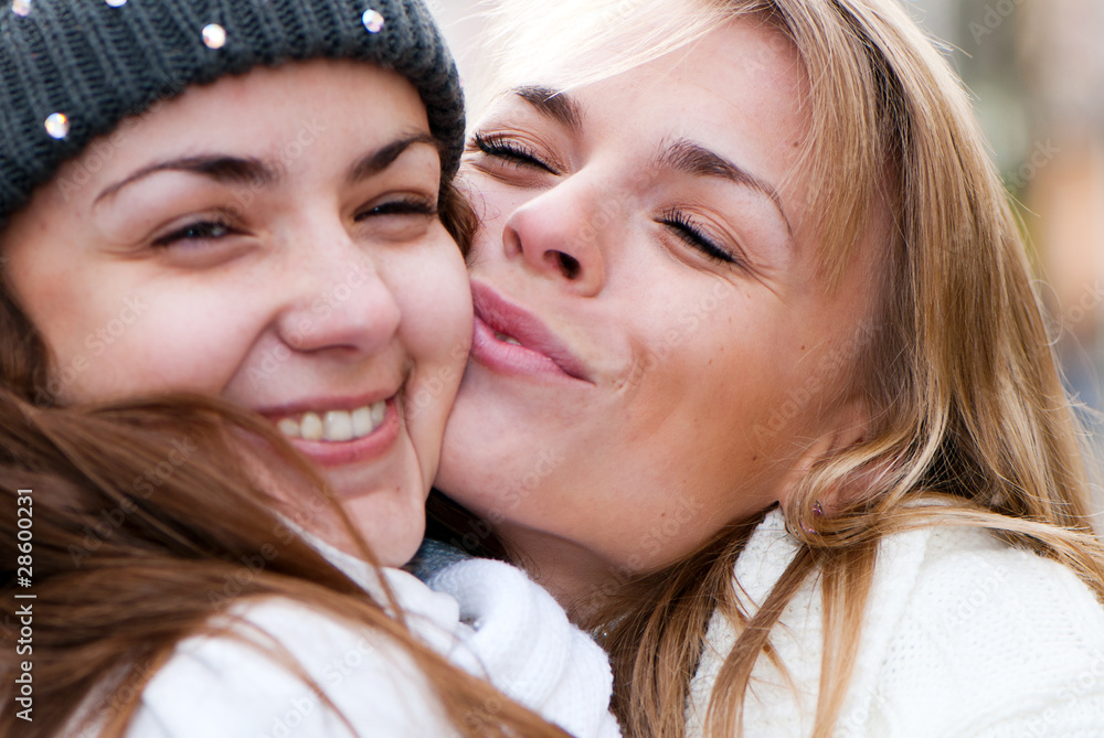 Two cheerful girls twins, in the street Two cheerful girls twins, in the street