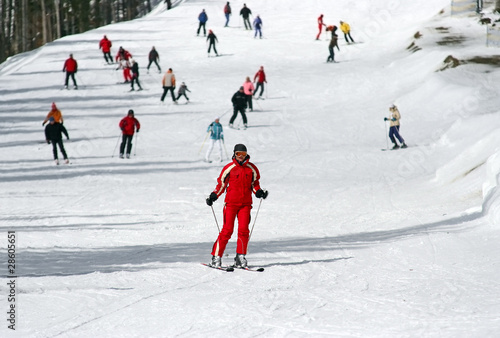 Female skier skiing down a wide track for beginners