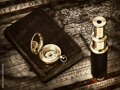 vintage telescope and compass at antique map