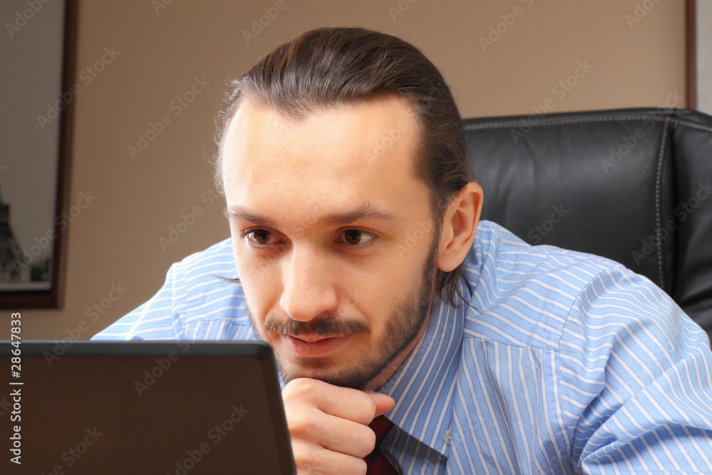 Businessman at his workplace look in laptop. Businessman at his workplace look in laptop.