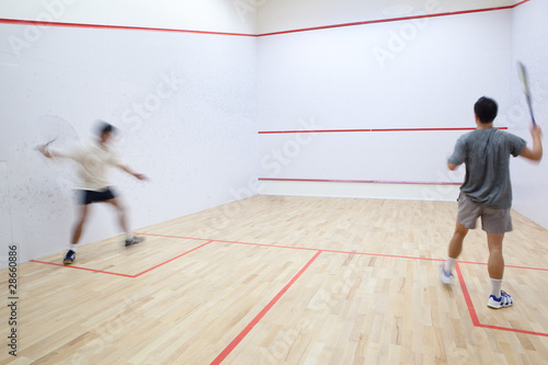Squash players in action on a squash court (motion blurred image © lightpoet