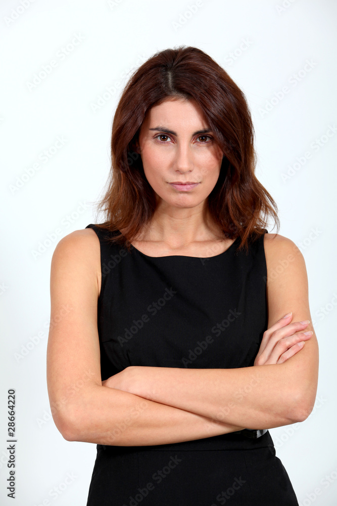 Woman in black dress with arms crossed on white background Woman in black dress with arms crossed on white background