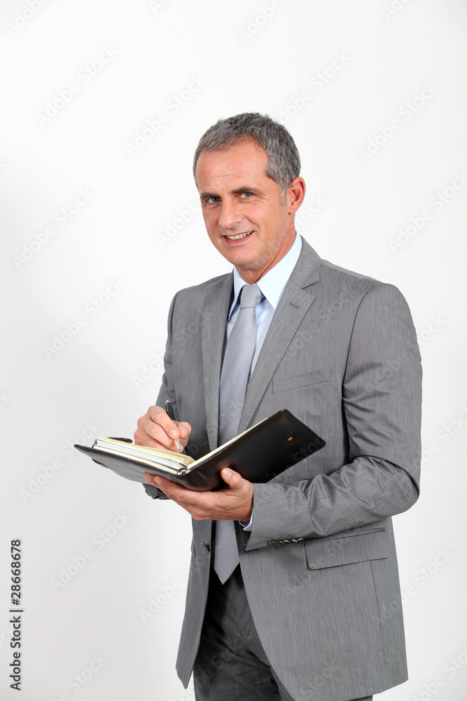 Businessman standing on white background with agenda Businessman standing on white background with agenda