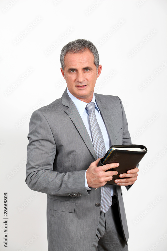 Businessman standing on white background with agenda Businessman standing on white background with agenda