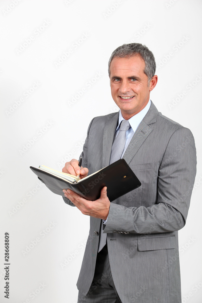 Businessman standing on white background with agenda Businessman standing on white background with agenda