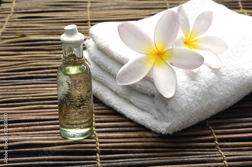 Frangipani on white towel with massage oil