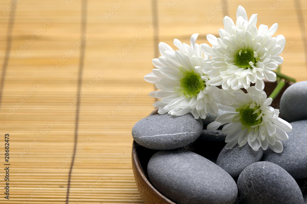Bowl of pebbles with Chrysanthemums flowers on mat Bowl of pebbles with Chrysanthemums flowers on mat