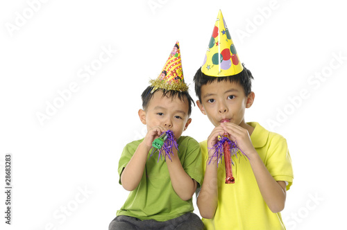 Young couple Boy Blowing a Party Favor and Wearing a Party Hat